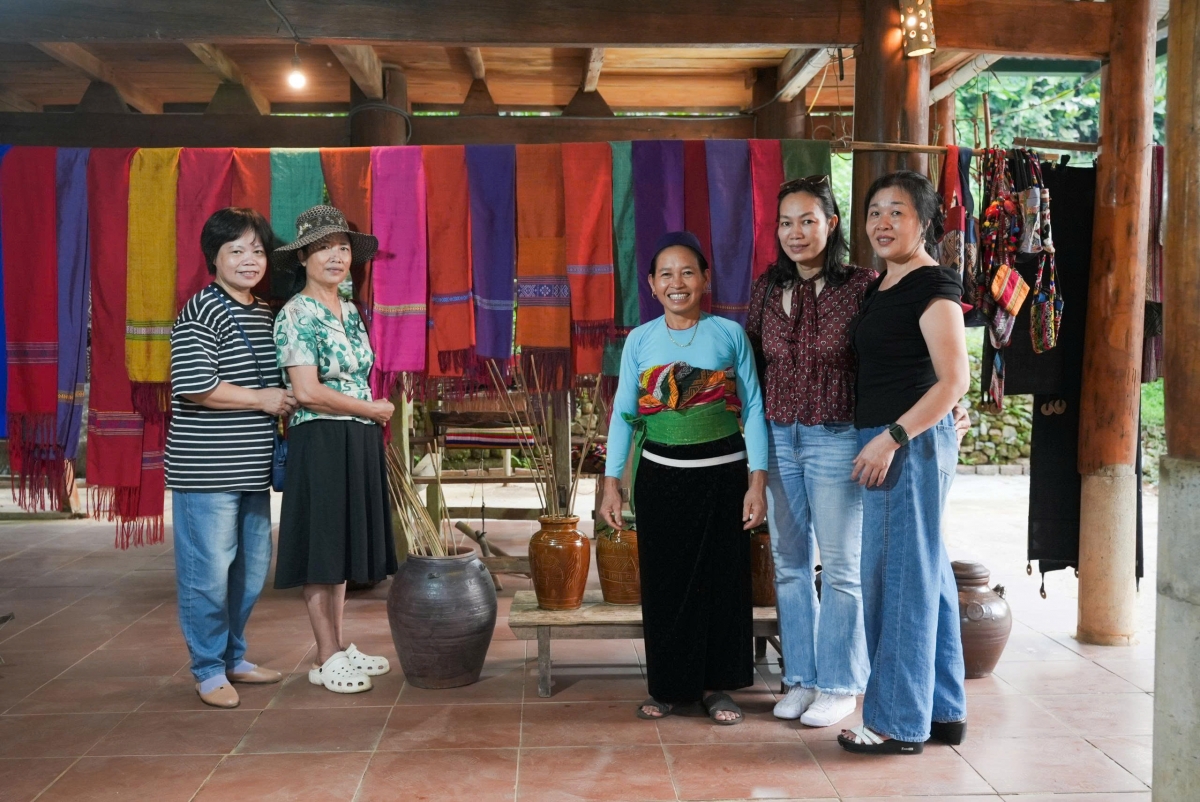 Du khách và người dân cùng chụp ảnh lưu niệm bên không gian trưng bày thổ cẩm, khép lại hành trình trải nghiệm đầy cảm xúc tại triển lãm “Man Kháu – Rice Up”.