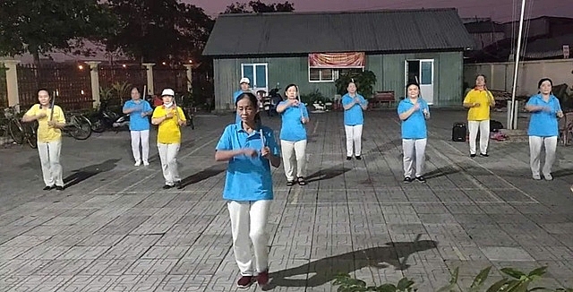 Bà Trần Mỹ Hạnh (đứng trước) tích cực dạy dưỡng sinh cho người cao tuổi mỗi buổi sáng