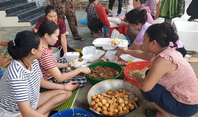 Nhóm tình nguyện viên thôn Ngư Thôn Đại Bản nhanh chóng nấu những suất cơm nóng hổi gửi cho người dân vùng lũ