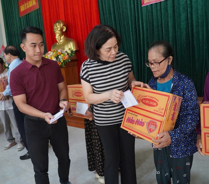 Bà Nguyễn Thị Tư và đại diện nhãn hãng King sport trao quà cho người dân 