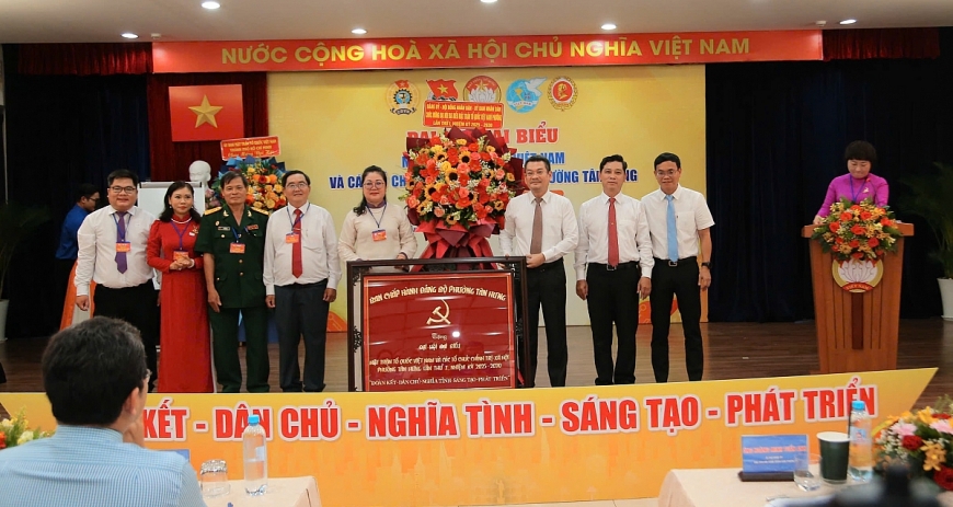 Ông Hoàng Minh Tuấn Anh, Bí thư Đảng uỷ, Chủ tịch Hội đồng Nhân dân phường Tân Hưng tặng hoa chúc mừng Ban Thường trực UBMTTQVN phường tại Đại hội