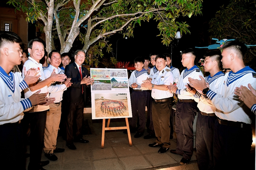  Cán bộ, chiến sỹ và các văn nghệ sỹ tham quan và chụp ảnh lưu niệm cùng nghệ sỹ Vũ Tiến Dũng tại triển lãm.