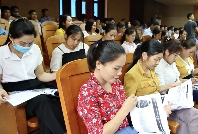 Người dân đọc tài liệu tuyên truyền về các quy định của Pháp luật về quản lý hoạt động kinh doanh đa cấp