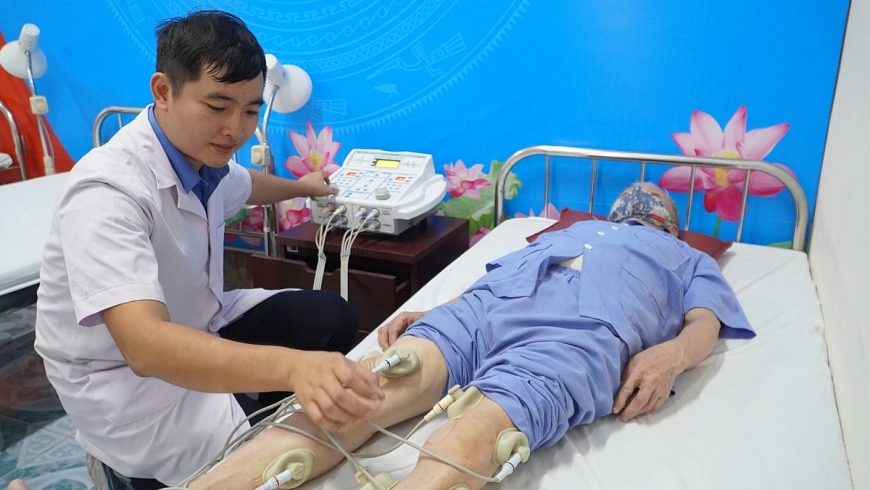 Bác sĩ Đặng Hữu Vũ thăm khám, chăm sóc sức khoẻ cho cụ ông đang điều trị tại Trung tâm.