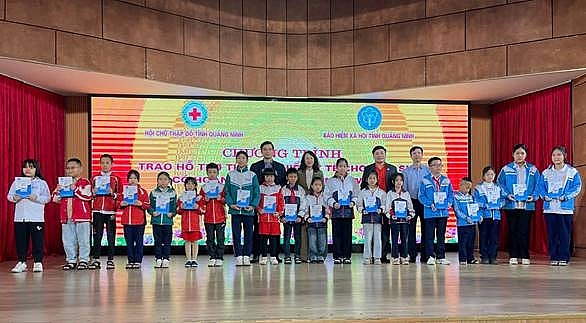 Đại diện Lãnh đạo Ban Tuyên Giáo và Dân vận Tỉnh ủy, Hội Chữ thập đỏ  và Bảo hiểm xã hội tỉnh Quảng Ninh trao thẻ bảo hiểm cho các cháu học sinh có hoàn cảnh khó khăn trên địa bàn. (Ảnh: Hội chữ thập đỏ).