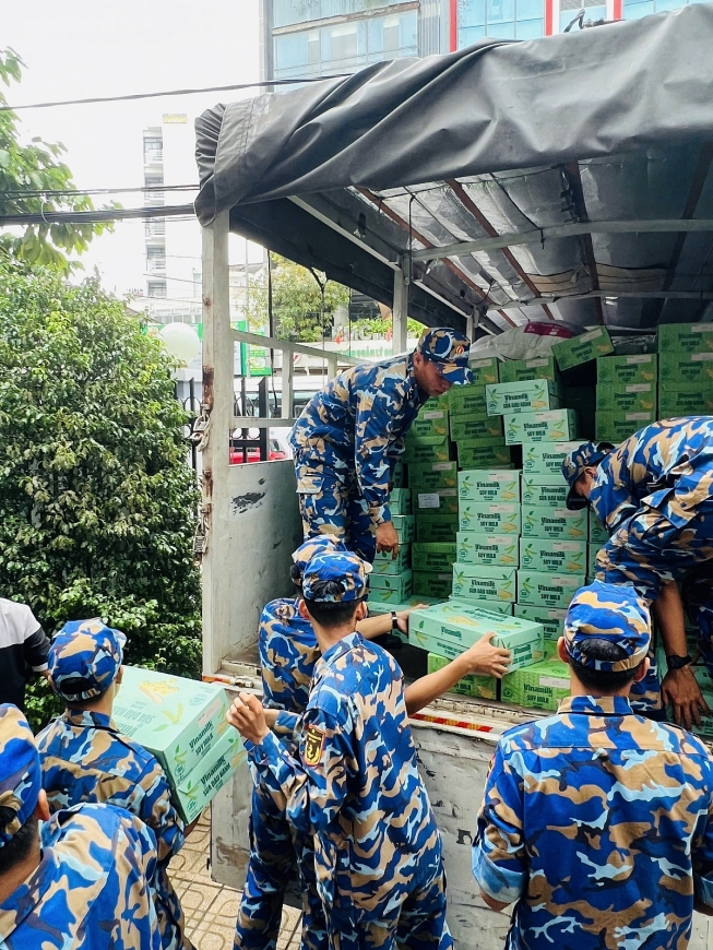 Các chiến sĩ Trung tâm Huấn luyện Vùng 4 Hải quân đang chuyền nhau các sản phẩm dinh dưỡng Vinamilk, sẵn sàng vận chuyển đến tận tay bà con vùng lũ - Ảnh: Vi Nam