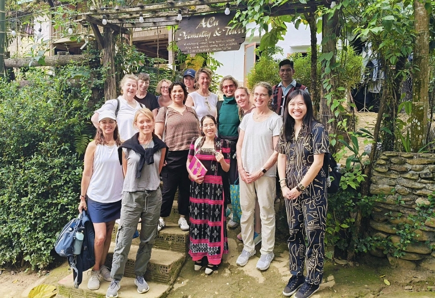 Chị Đinh Thị Thìn đón du khách nước ngoài đến thăm làng.