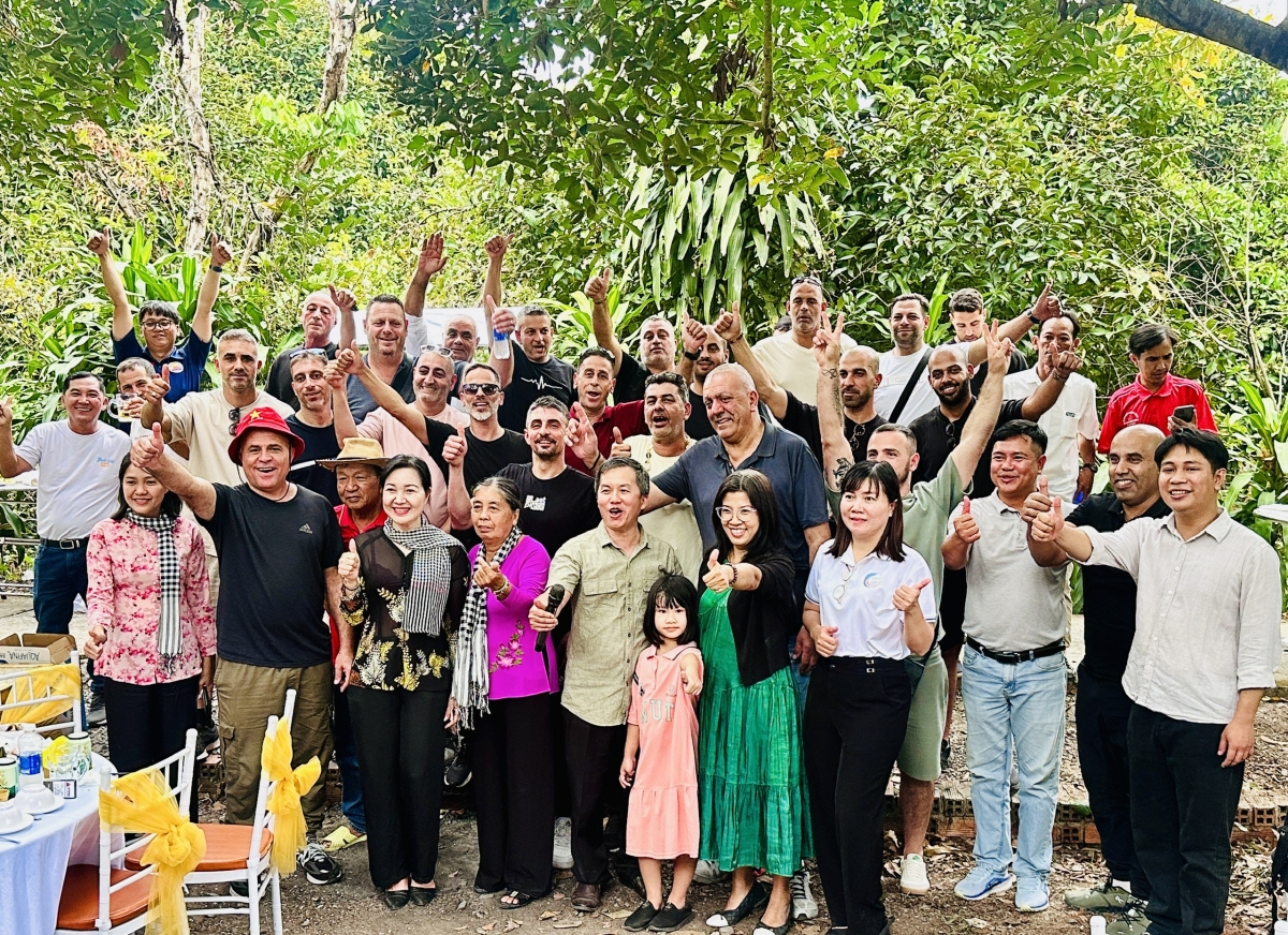 Du khách hào hứng chụp hình lưu niệm cùng lãnh đạo và bà con Nhân dân xã Bình Mỹ.