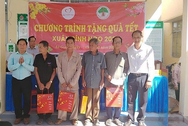 Ông Lê Thành Tân và ông Võ Văn Dừa trao quà Tết cho người cao tuổi có hoàn cảnh khó khăn.