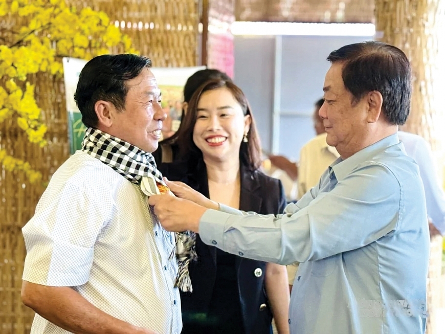 Phó Chủ tịch Quốc hội Lê Minh Hoan - Tác giả bài viết tặng khăn rằn biểu tượng Đất Sen hồng cho nông dân tham dự Tọa đàm chuyên đề “Người nông dân chuyên nghiệp” tại Đồng Tháp.