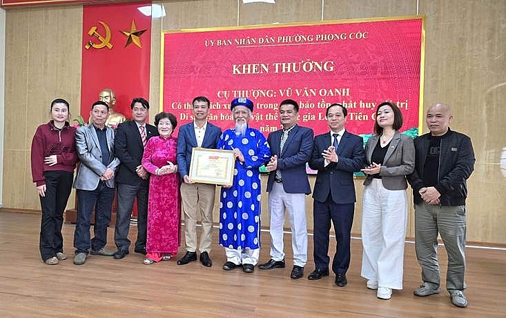    Ông Vũ Đức Hào, Phó Bí thư Thường trực Đảng ủy phường Phong Cốc(người thứ 5 từ trái sang) trao giấy khen của UBND phường Phong Cốc cho cụ thượng Vũ Văn Oanh vì có thành tích xuất sắc trong việc bảo tồn, phát huy giá  trị Di sản văn hóa phi vật thể quốc gia Lễ hội Tiên Công năm 2026.