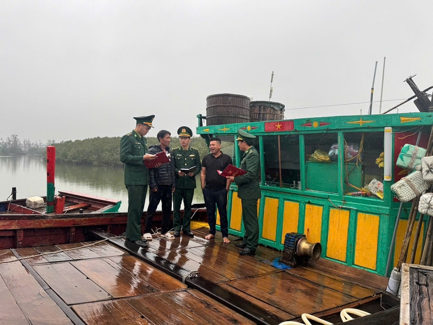 Cán bộ Đồn Biên phòng Cửa Sót tuyên truyền thông tin bầu cử cho ngư dân tại khu vực cầu cảng.