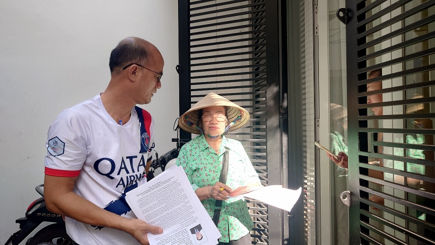 Ông Đinh Hữu Kỳ, Trưởng khu phố 33 và bà Nguyễn Thị Liên hội viên người cao tuổi đến từng nhà gửi thẻ cử tri, giải thích cho bà con về quyền bầu cử và ý nghĩa của cuộc bầu cử