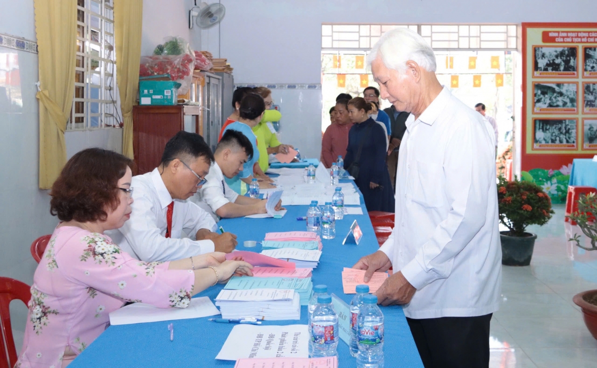 Cử tri cao tuổi phường Lái Thiêu thực hiện các bước nhận phiếu bầu tại khu vực bỏ phiếu số 29, khu phố Đông Tư.