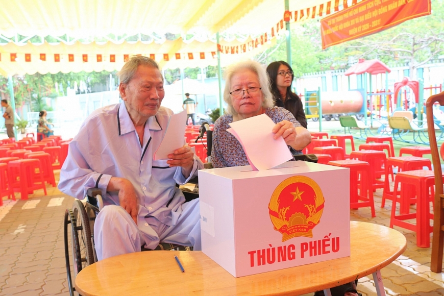 Hai cử tri đặc biệt ông Trần Minh Dân (sinh năm 1938) và vợ là bà Bùi Thị Xuân Lý (sinh năm 1943) cùng ngồi xe lăn đến bỏ phiếu bầu cử