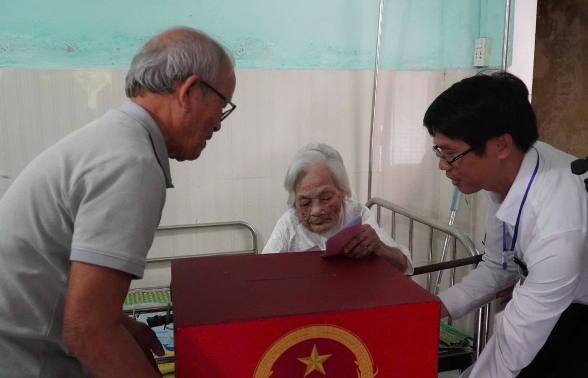 Cụ bà Đặng Thị Lãm, 116 tuổi, trú tại thôn Thạch Bồ, xã Hoà Vang, TP Đà Nẵng tự tay bỏ lá phiếu vào thùng khi tổ công tác của Uỷ ban bầu cử mang thùng phiếu phụ đến tận nhà, giúp cụ thực hiện quyền công dân
