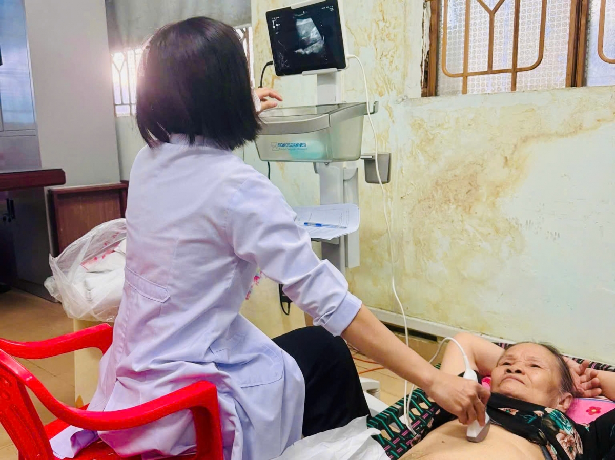 Nhân viên Trạm Y tế phường Tân Thuận đo huyết áp, tư vấn sức khỏe cho người cao tuổi tại chương trình khám miễn phí.