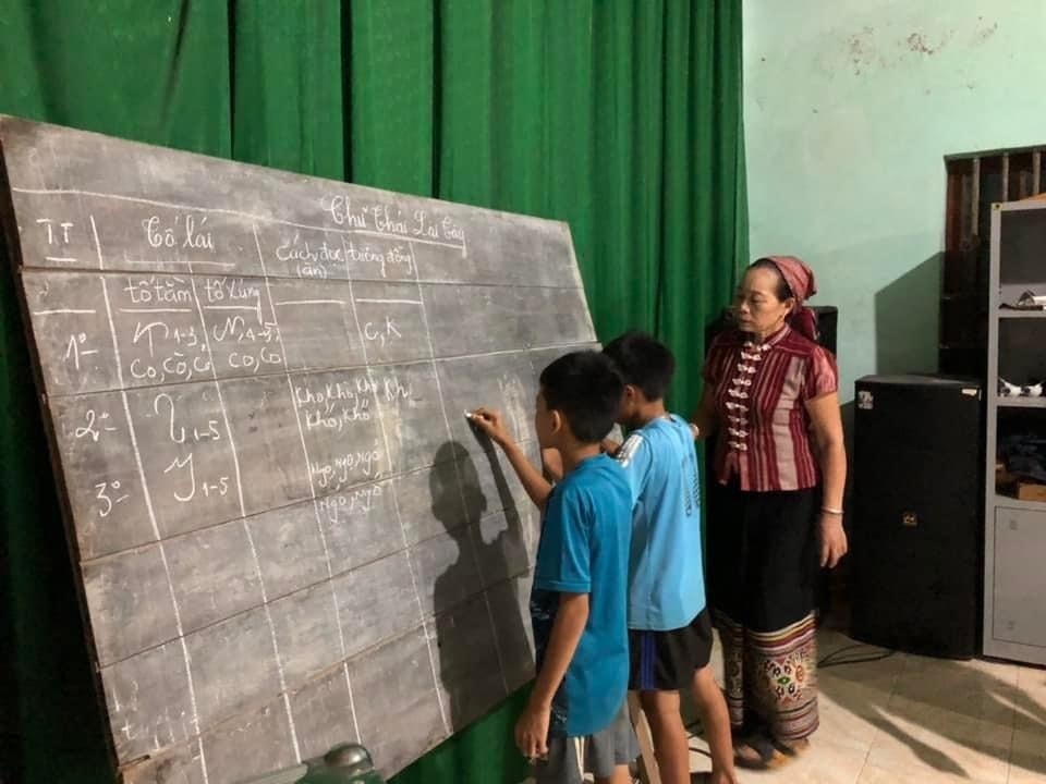 Nghệ nhân Sầm Thị Xanh bên lớp học chữ Thái của mình