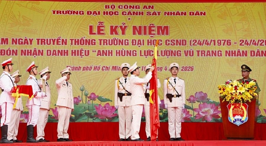 Thừa ủy quyền của Chủ tịch nước, Bộ trưởng Lương Tam Quang gắn huy hiệu Anh hùng Lực lượng vũ trang nhân dân lên Cờ truyền thống Trường Đại học Cảnh sắt nhân dân