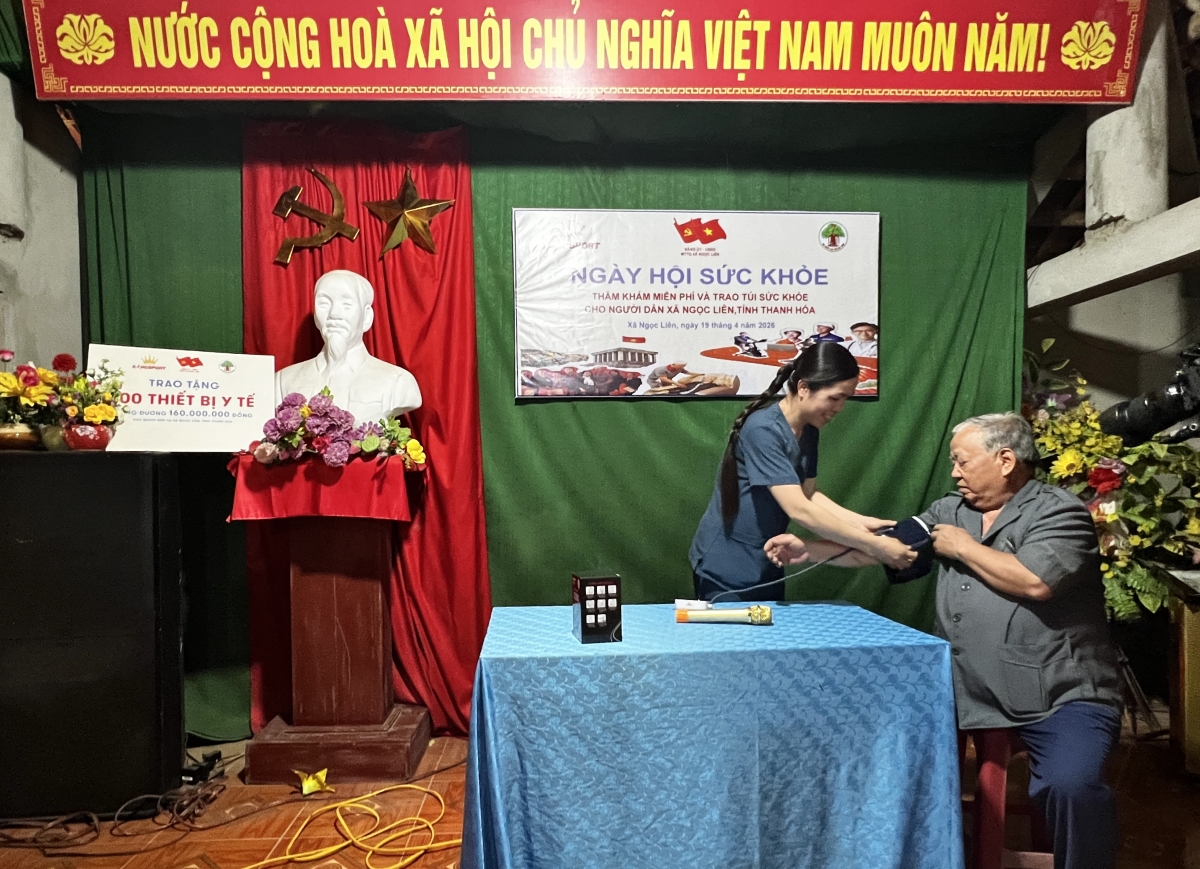 Cán bộ y tế hướng dẫn người cao tuổi sử dụng máy đo huyết áp