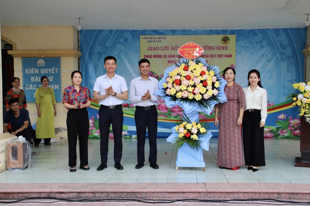 Đại diện lãnh đạo xã Tiên Du trao hoa chúc mừng Hội Người cao tuổi