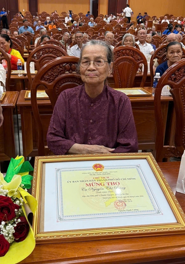 Cụ bà vinh dự nhận Giấy mừng thượng thọ 90 tuổi của Chủ tịch UBND Thành phố Hồ Chí Minh tại chương trình lễ chúc thọ, mừng thọ người cao tuổi năm 2026