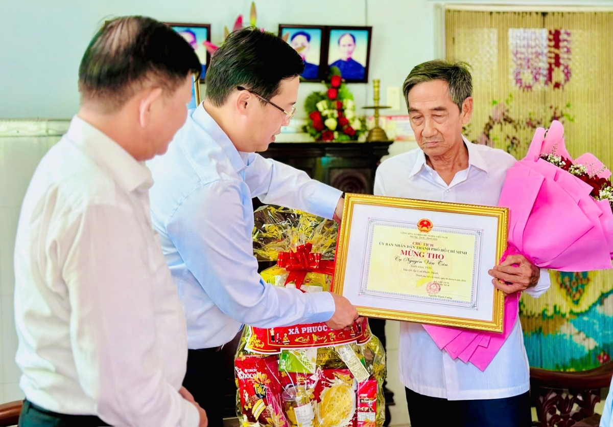 Đồng chí Lê Quốc Phong, Phó Bí thư Thường trực Thành ủy TP. Hồ Chí Minh trao thiệp mừng thọ của Chủ tịch UBND Thành phố cho cụ Nguyễn Văn Tân