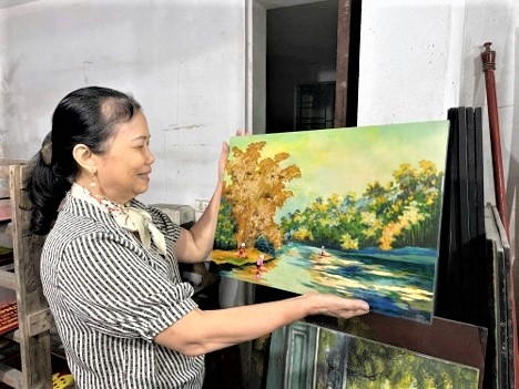 Nghệ nhân Nguyễn Thị Hồi bên sản phẩm của mình