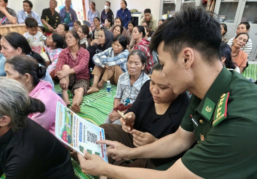 Cán bộ chiên sĩ Đồn Biên phòng Đắc Pring cầm tay, hướng dẫn cụ thể cho từng người dân.