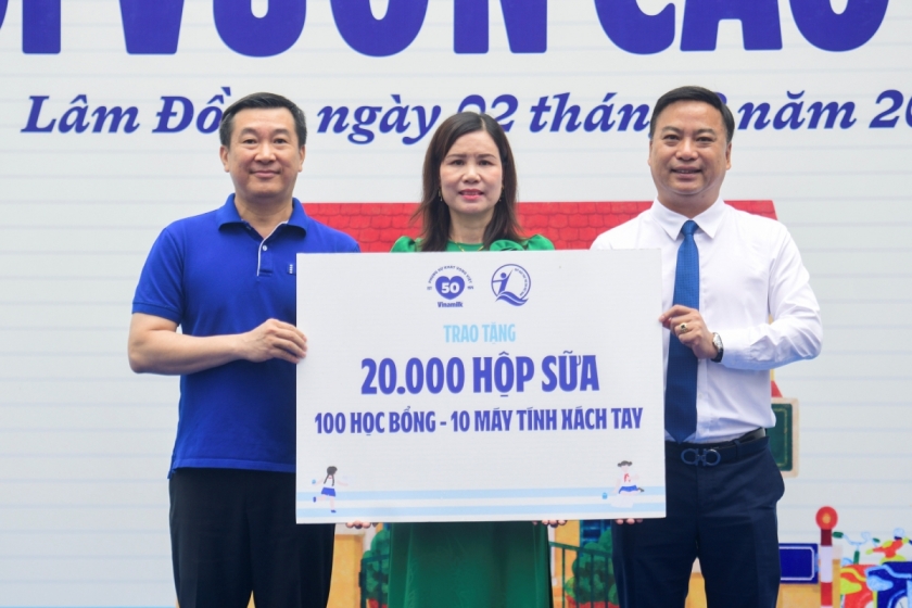 Đại diện Quỹ sữa Vươn cao Việt Nam, ông Đỗ Thanh Tuấn - Giám đốc Đối ngoại Vinamilk (bên trái) và ông Đinh Tiến Hải - Giám đốc Quỹ Bảo trợ Trẻ em Việt Nam - trao bảng tượng trưng các phần quà thiết thực cho đại diện Trường Tiểu học An Hiệp, xã Hiệp Thạnh (Ảnh: Hải An).