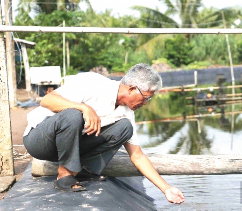 Ông Trần Văn Hưng, kiểm tra nguồn nước tại ao nuôi tôm của gia đình Làm giàu từ mô hình nuôi tôm
