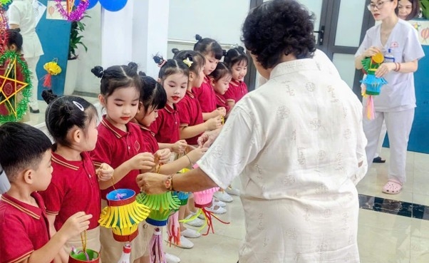 Người cao tuổi trao tặng đèn  lồng tự làm cho các cháu thiếu nhi
