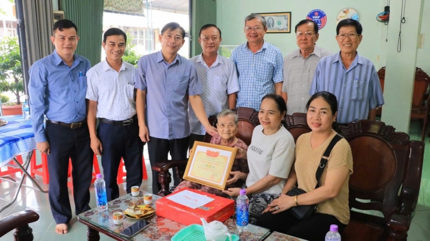 Bí thư  Đảng uỷ xã Tràm Chim (đứng thứ 3 bên trái qua) thăm tặng quà mừng thọ cụ bà 85 tuổi ở địa phương.