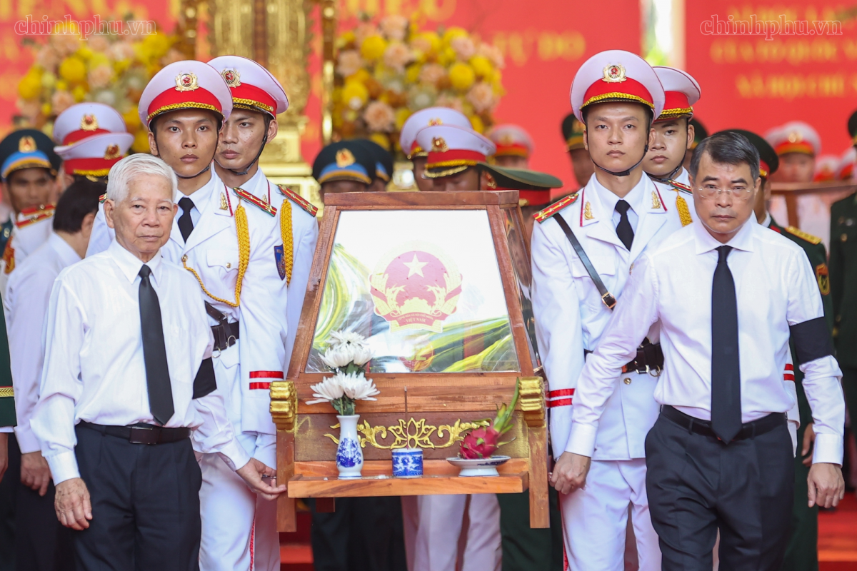 Thủ tướng Chính phủ Lê Minh Hưng và nguyên Chủ tịch nước Nguyễn Minh Triết di chuyển giá khiêng hài cốt liệt sĩ lên xe để đến Nghĩa trang liệt sĩ Thành phố Hồ Chí Minh - Ảnh: chinhphu.vn