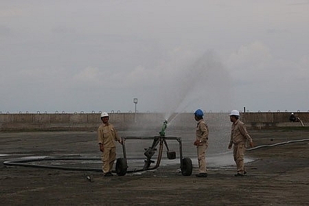 Tạo ẩm tại bãi trữ tro, xỉ tại NMNĐ Duyên Hải 1. Ảnh: VGP/ Toàn Thắng