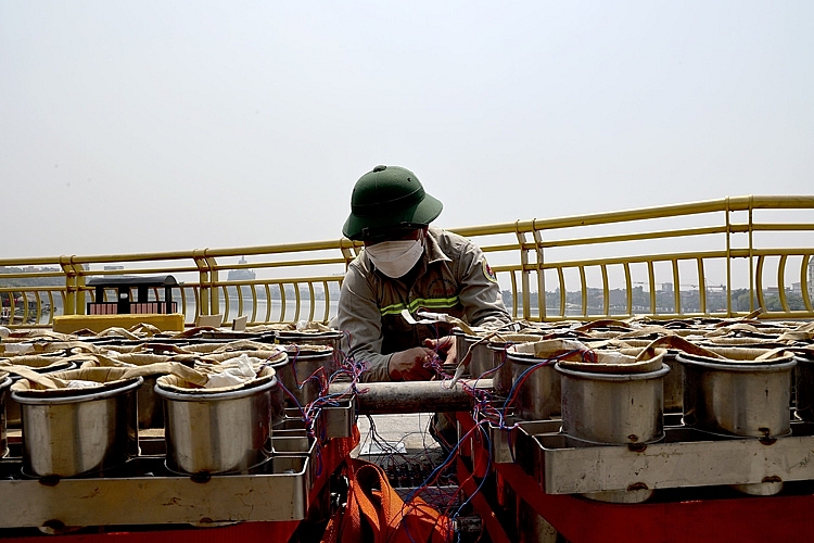 Nhân viên kỹ thuật kết nối dây từng thùng với bảng điều khiển một cách cẩn thận.