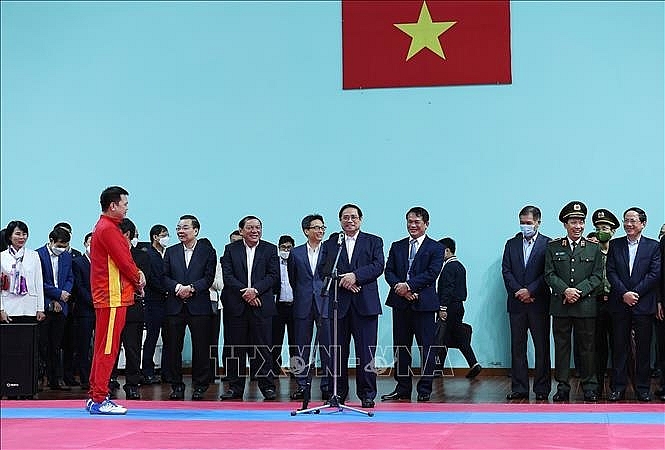 Thủ tướng Phạm Minh Chính động viên các huấn luyện viên và vận động viên đang tập luyện chuẩn bị tại Trung tâm Huấn luyện thể thao quốc gia. Ảnh: Dương Giang/TTXVN