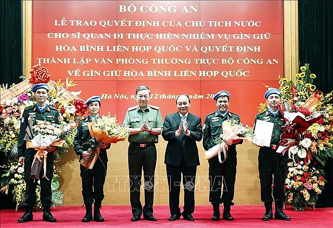 hủ tịch nước Nguyễn Xuân Phúc trao Quyết định cho Trung tá Nguyễn Ngọc Hải làm nhiệm vụ tại Trụ sở Liên hợp quốc và tặng hoa cho 3 đồng chí đi thực hiện nhiệm vụ tại Phái bộ Nam Sudan. Ảnh: Thống Nhất/TTXVN