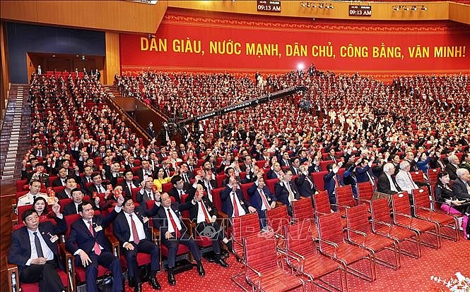 Các đại biểu biểu quyết, thông qua Nghị quyết Đại hội XIII Đảng Cộng sản Việt Nam. Ảnh: TTXVN