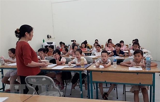 Nghệ nhân Ưu tú Kim Dung dạy các em nhỏ trong Câu lạc bộ dân ca làng Mọc Quan Nhân. (Nguồn: TTXVN phát)