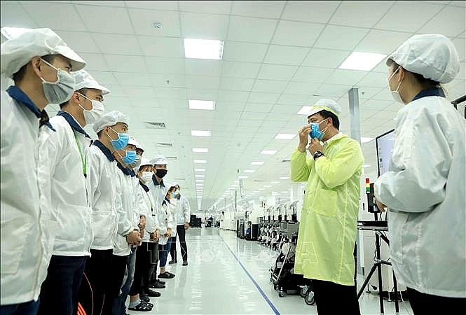 Công đoàn hướng dẫn cho công nhân đeo khẩu trang đúng cách để phòng dịch COVID- 19. Ảnh: Hoàng Hùng/TTXVN