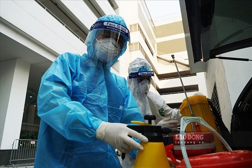 Cán bộ y tế có mặt tại khu vực phong tỏa nơi ở của 2 bệnh nhân COVID-19 đến khám tại BV Hữu nghị Việt- Xô. Ảnh: Tùng Giang