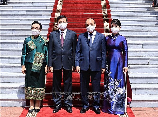Chủ tịch nước Nguyễn Xuân Phúc và Phu nhân chụp ảnh chung với Tổng Bí thư, Chủ tịch nước Lào Thongloun Sisoulith và Phu nhân tại lễ đón. Ảnh: Thống Nhất/TTXVN