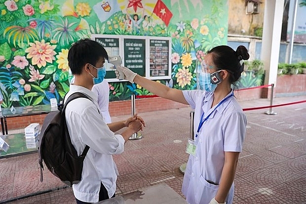 Học sinh Hà Nội kiểm tra thân nhiệt, khử khuẩn trong đợt 1 kỳ thi tốt nghiệp trung hoc phổ thông. (Ảnh: Minh Sơn/Vietnam+)