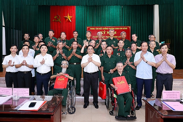 Thủ tướng cùng đoàn công tác chụp ảnh lưu niệm cùng các thương binh, bệnh binh tại Trung tâm - Ảnh: VGP/Nhật Bắc