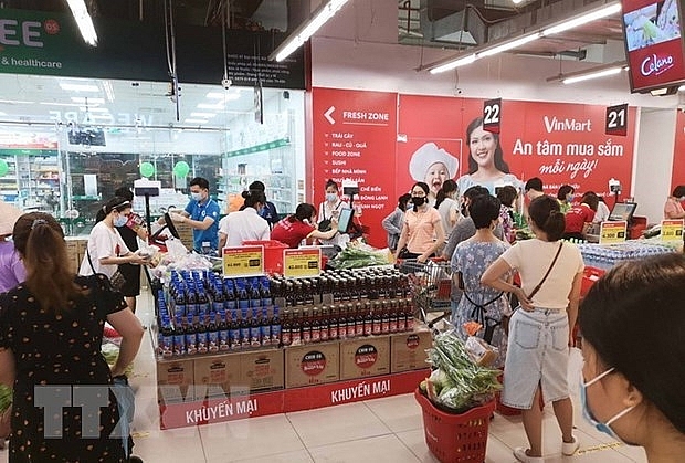 Người dân đi mua sắm tại siêu thị VinMart-Times City sáng 24/7 vừa qua. (Ảnh: Thanh Tùng/TTXVN)