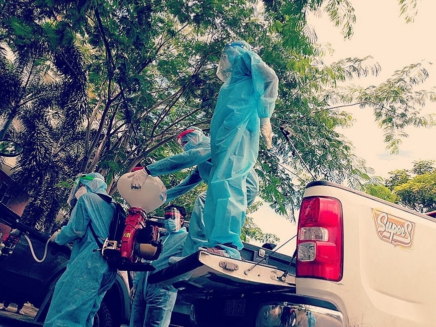 Ảnh 2: Tất cả các thành viên mặc đồ bảo hộ kỹ càng, trên vai đeo bình dung dịch nặng khoảng 40kg