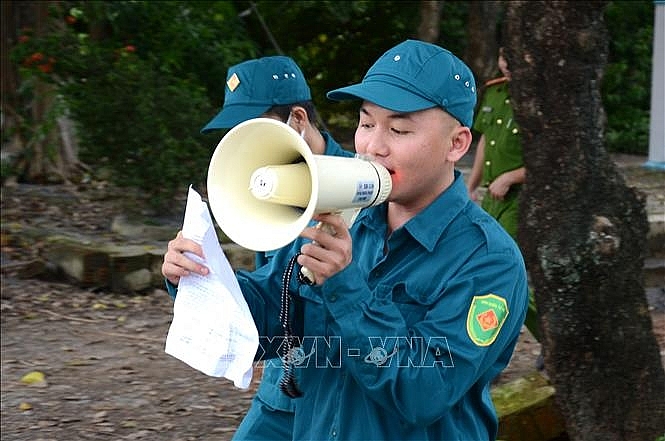 Lực lượng chức năng kêu gọi, vận động người dân trong khu vực nguy hiểm nhanh chóng di dời tránh bão số 9. Ảnh: Quốc Dũng/TTXVN