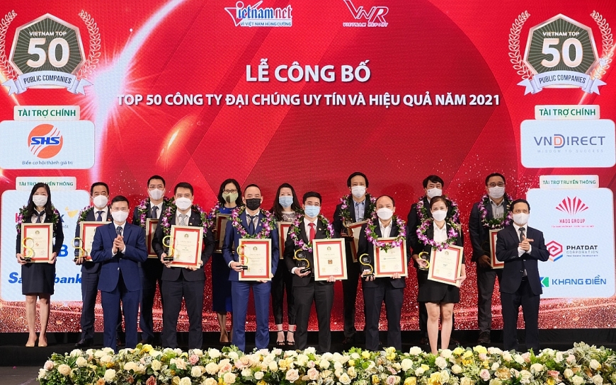 Đại diện Vietcombank (thứ 4 từ phải sang, hàng sau) và các đơn vị trong Top 50 công ty đại chúng uy tín và hiệu quả năm 2021 nhận vinh danh từ Ban tổ chức chương trình