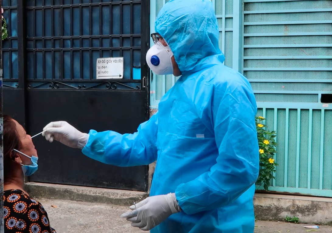 Nhân viên y tế lấy mẫu xét nghiệm tại hẻm 106 đường Bình Tiên (phường 3, quận 6, TPHCM) - nơi có nhà của bệnh nhân 1347 mắc COVID-19. Ảnh: Hữu Huy